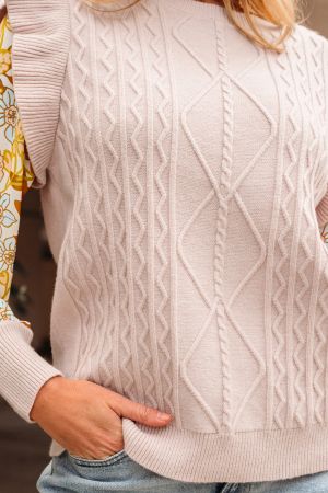 close up cable knit texture on beige women’s sweater
