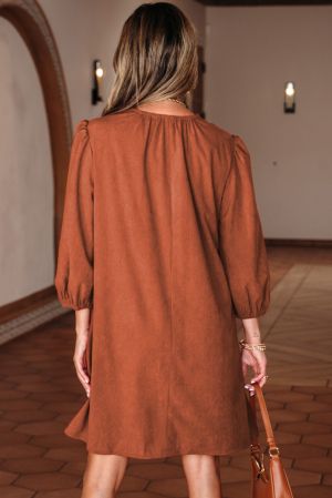 Back view of women’s cinnamon dress with puff sleeves and loose silhouette